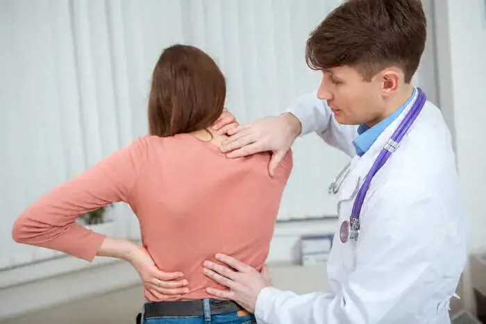 A rheumatologist in Riverside examining a patient's back